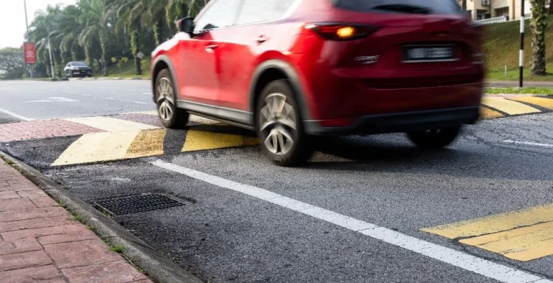 red car driving over speed ramp