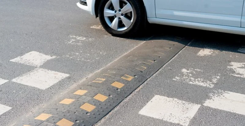 small car driving over speed bump
