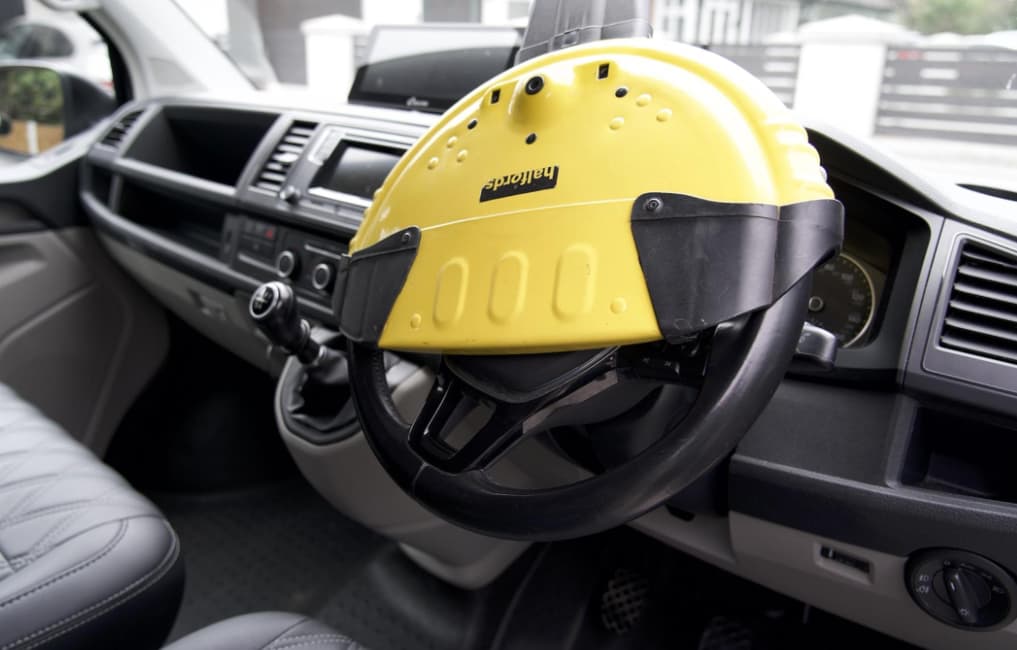 Heavy-duty metal full-cover steering wheel lock fitted inside a car
